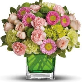 Pink and green mixed bouquet in a square glass vase