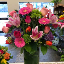 Pink and peach mixed bouquet in a tall glass vase