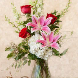 Pink lilies and red roses in a glass vase