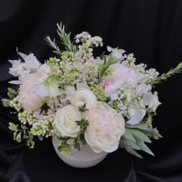 White floral arrangement in a round white vase