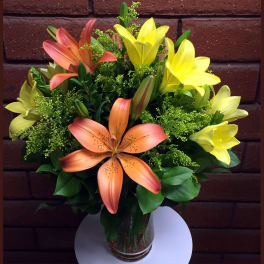 Bouquet of orange and yellow lilies in a glass vase