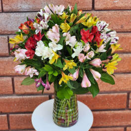 Mixed bouquet of colorful alstroemeria in a glass vase