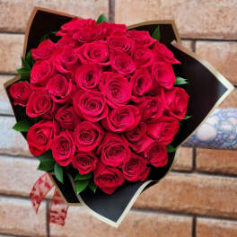 Bouquet of red roses wrapped in black paper