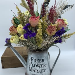 Dried flower arrangement in a metal watering can