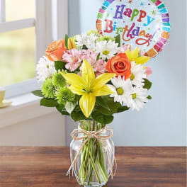 Mixed bouquet in a glass jar with a birthday balloon