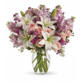 Pink roses and white lilies in a clear glass vase