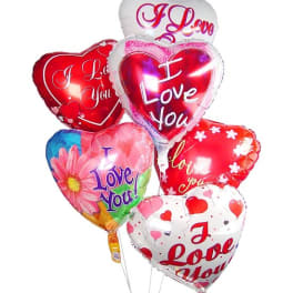 Cluster of heart-shaped foil balloons with I Love You messages in red, pink, and white.