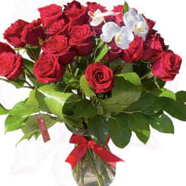Bouquet of red roses with white orchids in a glass vase