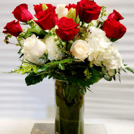 Red and white roses arranged in a tall glass vase