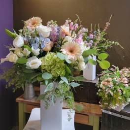 Mixed pastel bouquet in a tall white vase with gerberas, roses, and hydrangeas