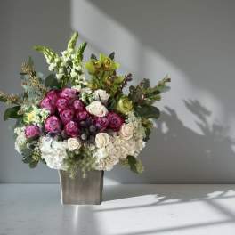 Bouquet of pink and white roses in a square vase