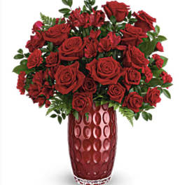 Red roses and red alstroemeria in a tall red vase