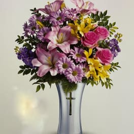 Bouquet of pink, purple, and yellow flowers in a clear glass vase