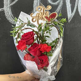 Bouquet of red roses and carnations with a decorative topper