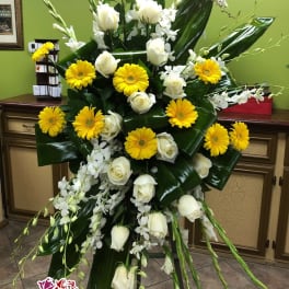 Tall floral standing spray with white roses, yellow gerbera daisies, and orchids