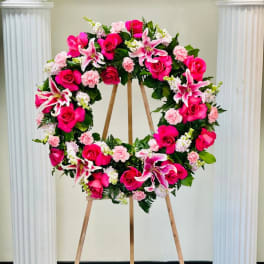Pink and white floral wreath on a wooden easel