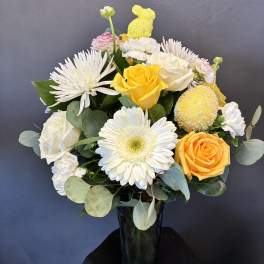 Yellow and white roses with white daisies in a dark vase