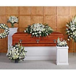 White floral funeral arrangements around a casket