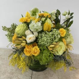 Yellow and white floral arrangement in a dark vase