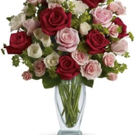 Bouquet of red, pink, and white roses in a clear glass vase