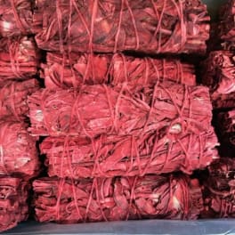 Bundles of red dried plant material tied with string in a tray