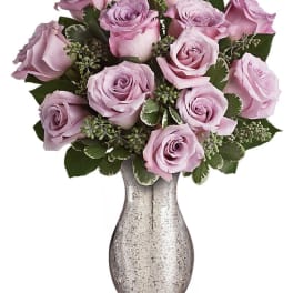 Lavender roses arranged in a silver vase