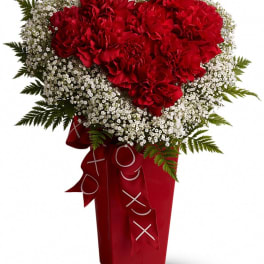Red carnation bouquet with white baby's breath in a red vase