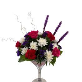 Mixed bouquet in a martini glass with pink roses, white daisies, and red carnations