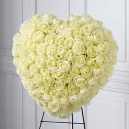 Heart-shaped arrangement of cream roses on a stand
