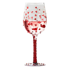 Clear wine glass decorated with red heart confetti