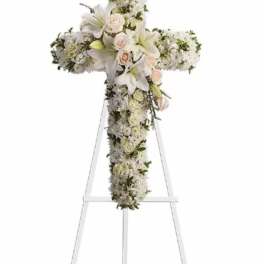 White floral cross arrangement on an easel