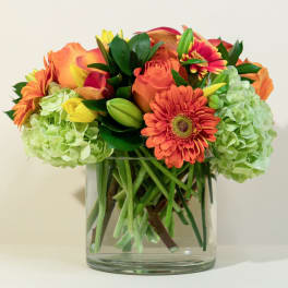 Orange and yellow mixed bouquet in a clear glass vase