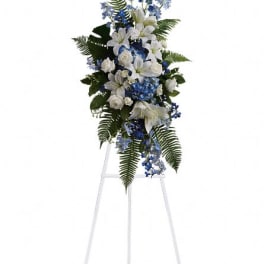 White and blue funeral spray on a standing easel