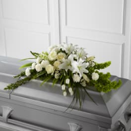 White floral spray on a gray casket