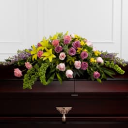 Casket spray with pink and yellow flowers