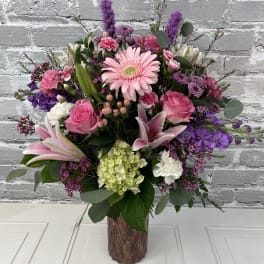 Pink and purple mixed flower arrangement in a glass vase