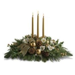 Holiday centerpiece with three gold candles and evergreen decorations