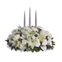 White floral centerpiece with three tall candles