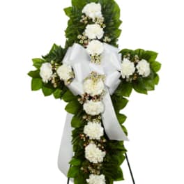 White floral standing cross with ribbon on an easel
