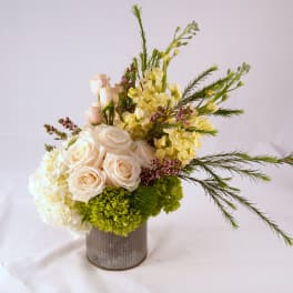 Cream roses and pale yellow flowers in a gray vase