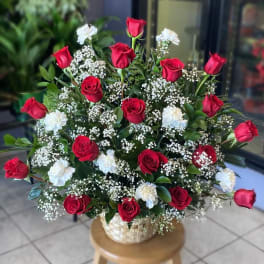 Red roses and white carnations in a woven basket