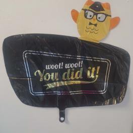 Black congratulatory balloon with a cartoon owl topper