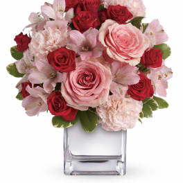Pink and red roses with pale pink alstroemeria in a clear glass vase