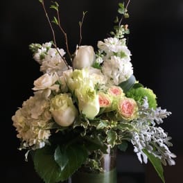 White and pale pink floral arrangement in a glass vase