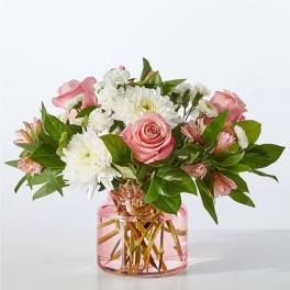 Pink roses and white daisies in a pink glass vase
