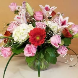 Pink and white mixed flower arrangement in a glass vase