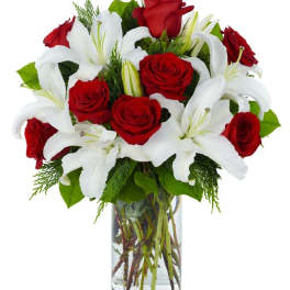 Red roses and white lilies in a clear glass vase