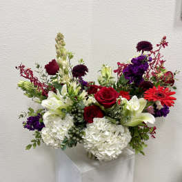 Mixed bouquet of red, white, and purple flowers in a vase