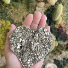 Hand holding a metallic heart-shaped crystal cluster
