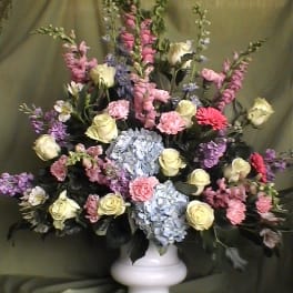 Mixed pastel flower arrangement in a white vase